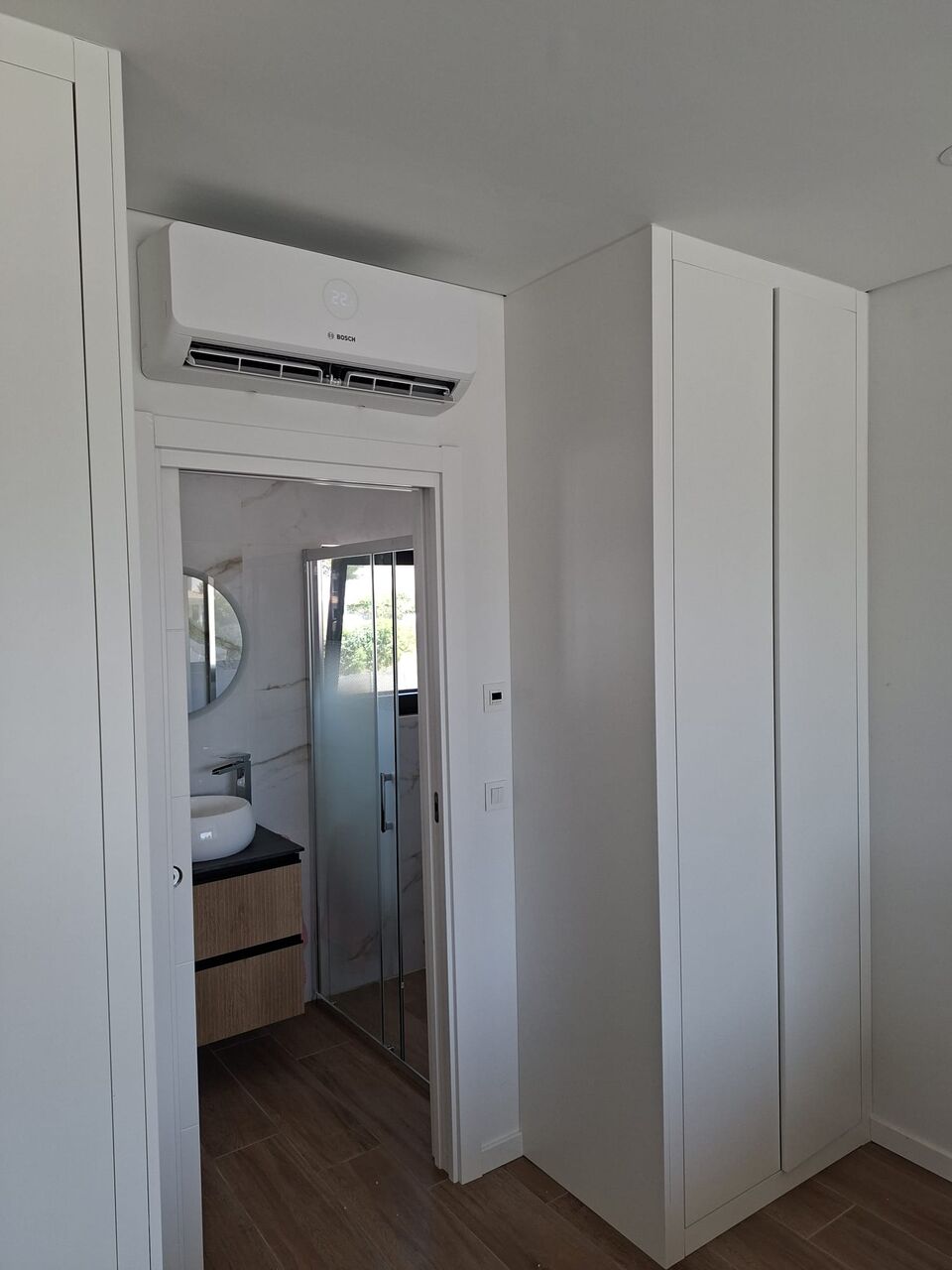 Unidade interior de ar condicionado Bosch instalada sobre porta de closet, Quinta da Balaia, Albufeira