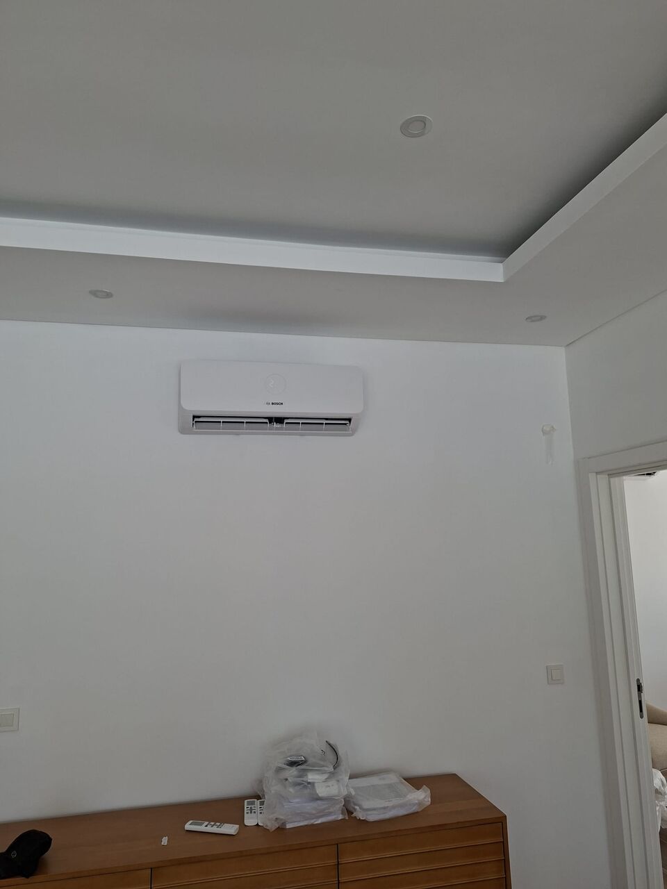 Unidade interior de ar condicionado Bosch instalada sobre móvel de quarto, Quinta da Balaia, Albufeira