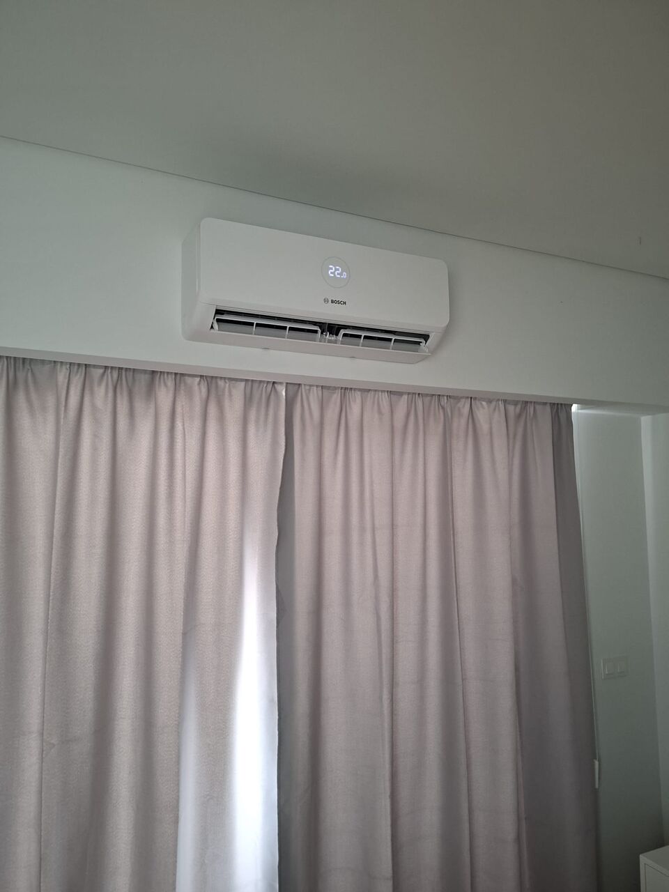 Unidade interior de ar condicionado Bosch instalada junto a cortinado, Quinta da Balaia, Albufeira