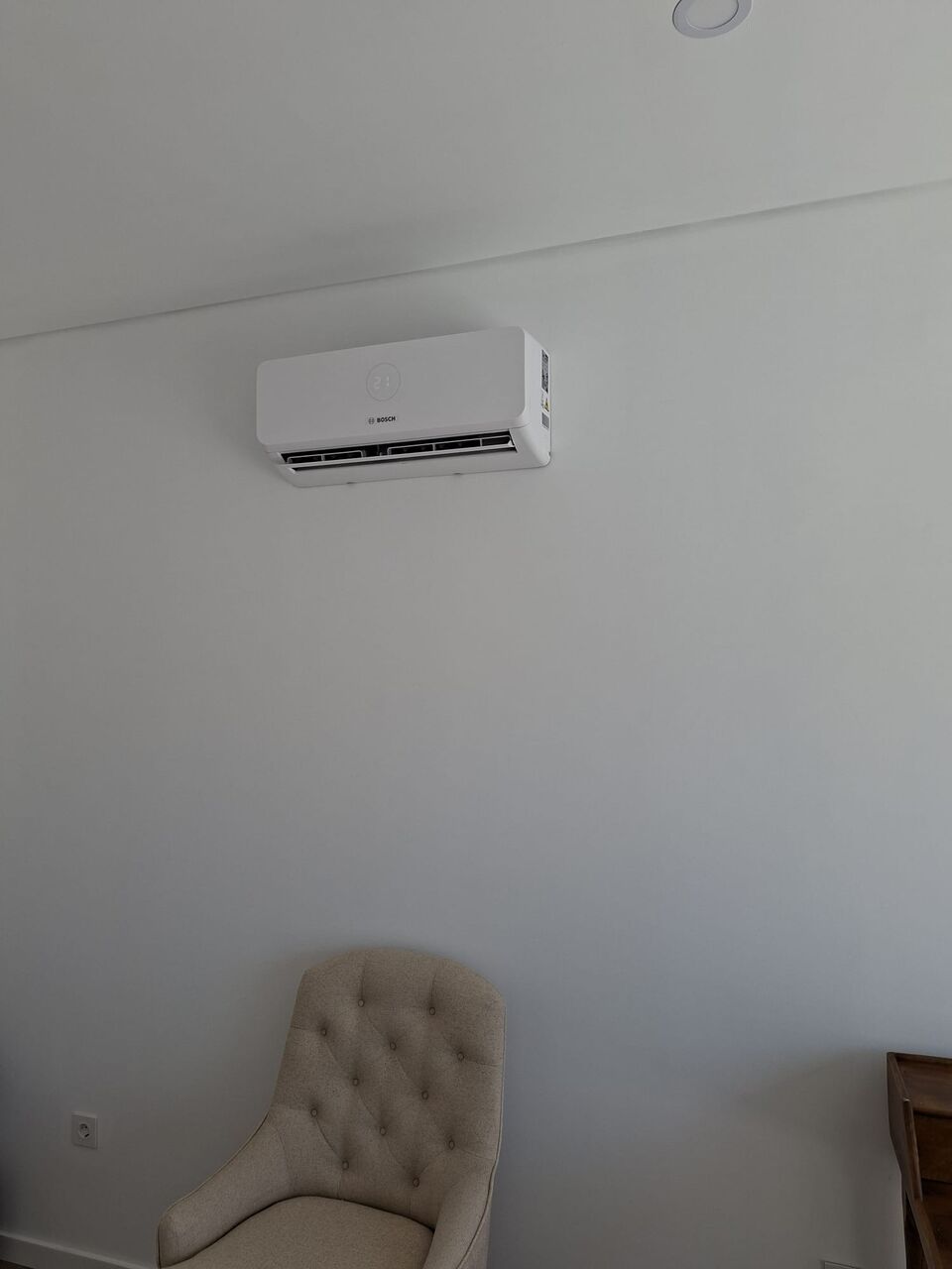 Unidade interior de ar condicionado Bosch instalada em quarto com poltrona, Quinta da Balaia, Albufeira