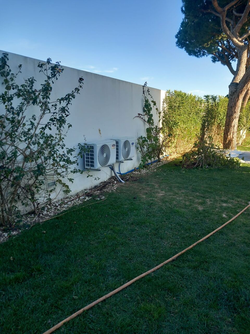 Unidade exterior de ar condicionado Carrier montada em jardim de moradia, Quinta do Lago, Loulé