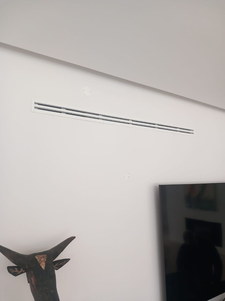 Grelha de ar condicionado por condutas embutida em parede de sala, Quinta do Lago, Loulé