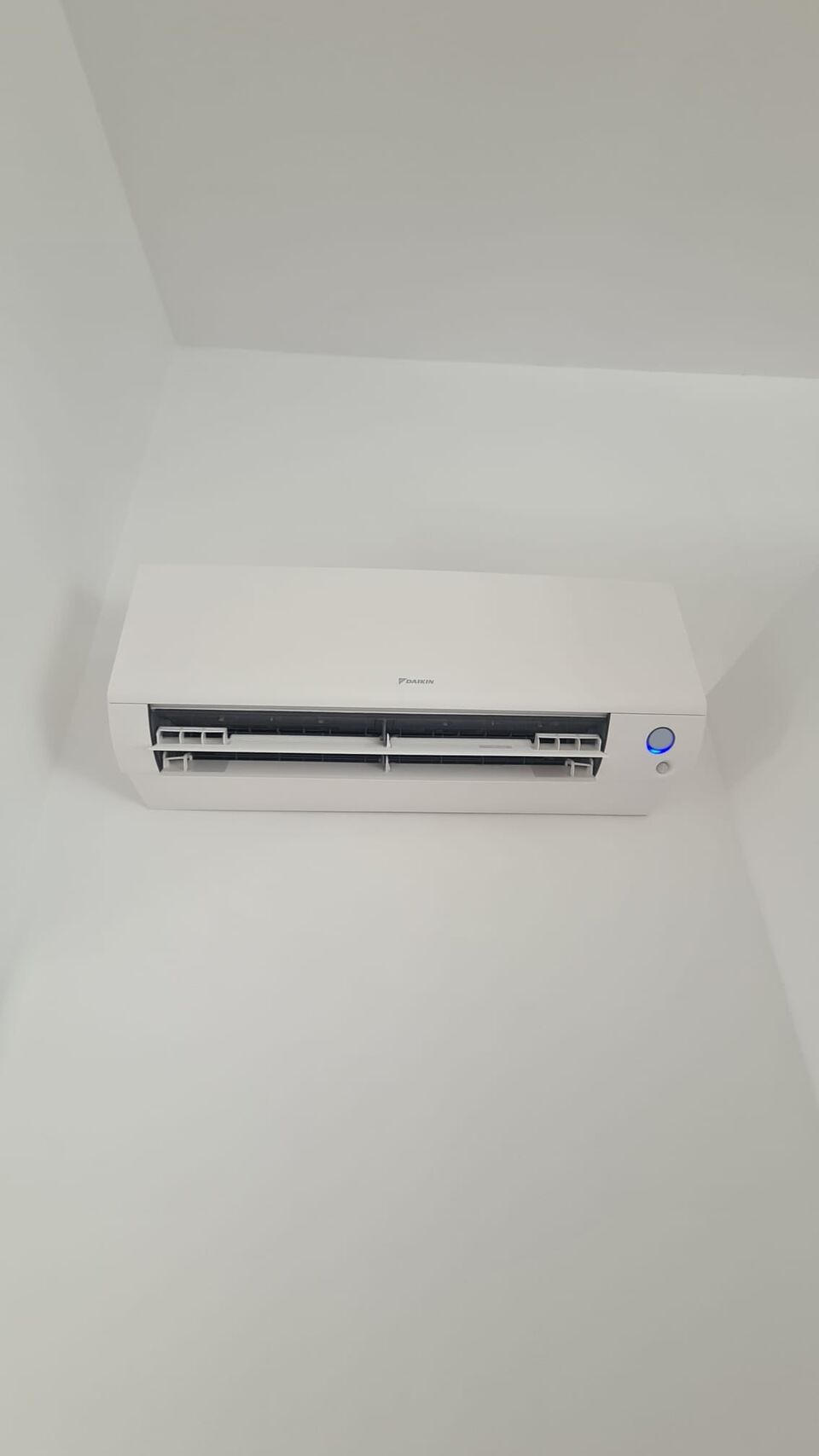 Unidade interior de ar condicionado Daikin instalada em parede branca, Alvor