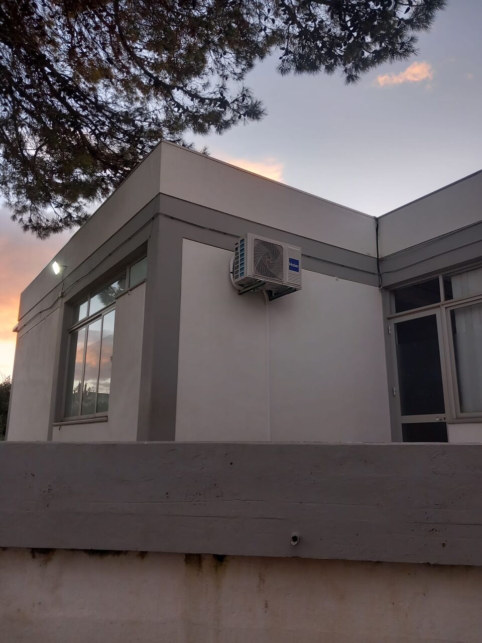 Unidade exterior de ar condicionado Haier montada na fachada de escola primária, Portimão