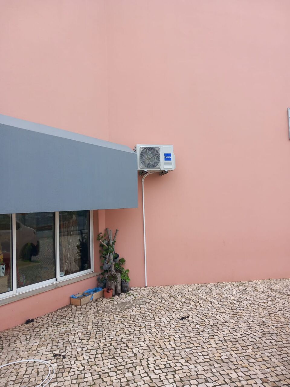 Unidade exterior de ar condicionado Haier montada na parede de escola primária, Portimão