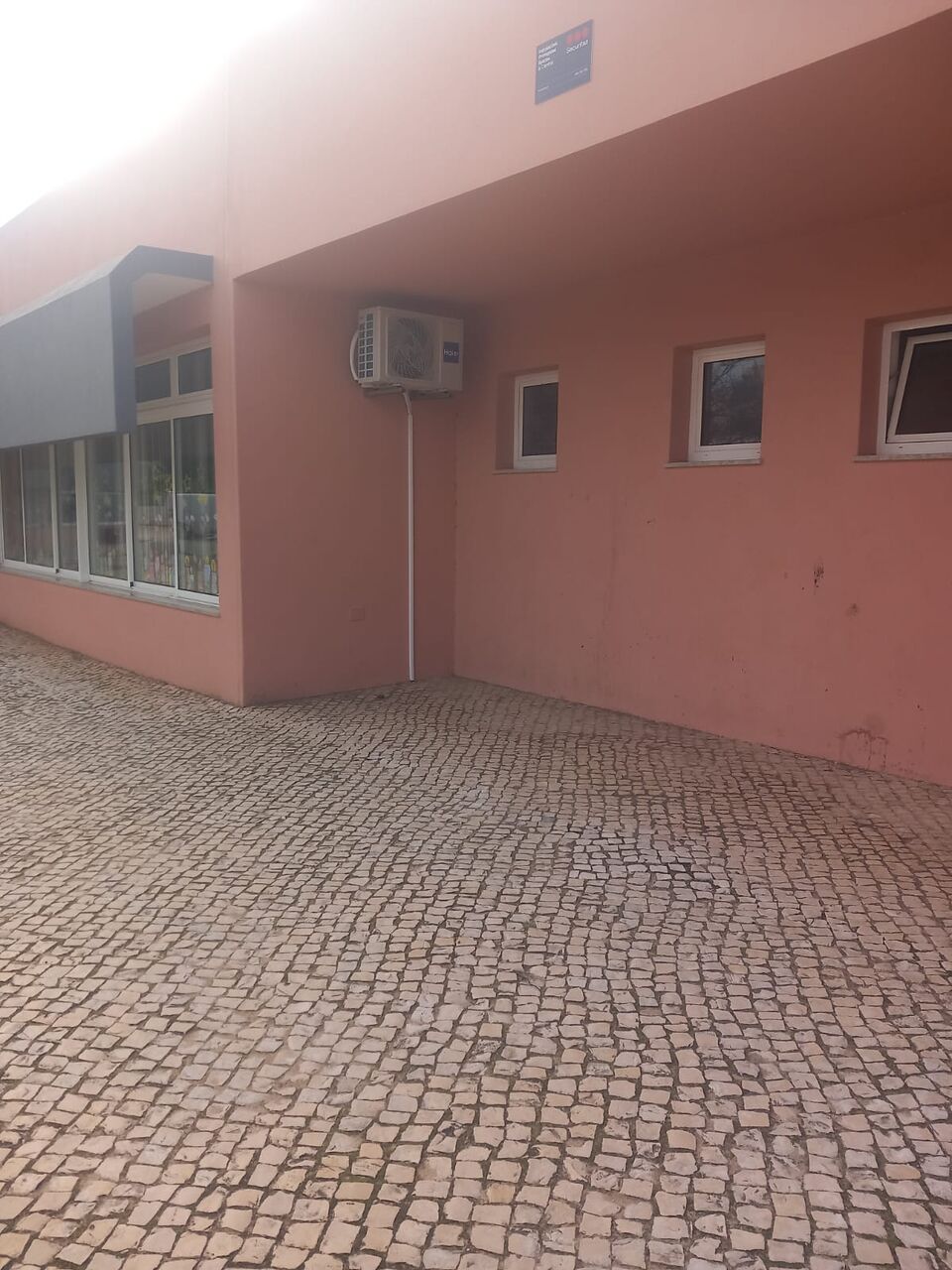 Unidade interior de ar condicionado Haier instalada em corredor de escola, Portimão