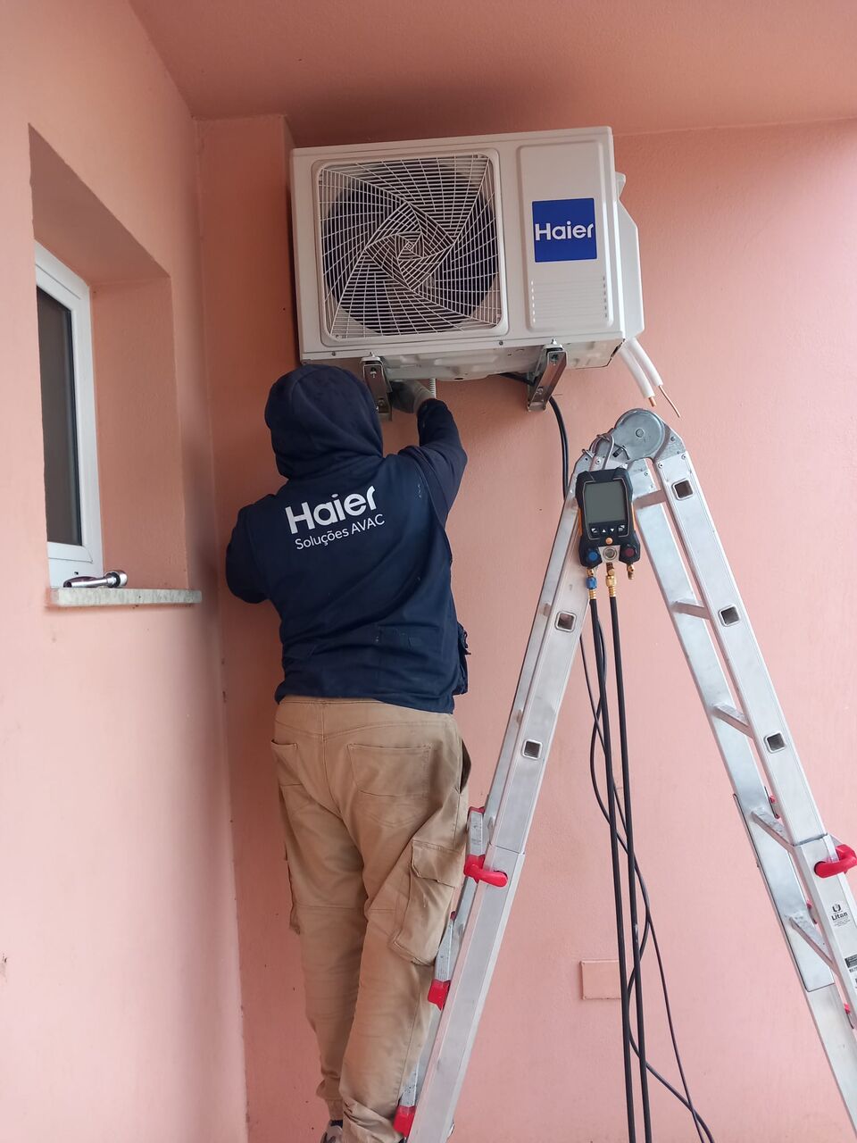 Técnico da DM Clima a instalar ar condicionado Haier em sala de aula, escola primária em Portimão