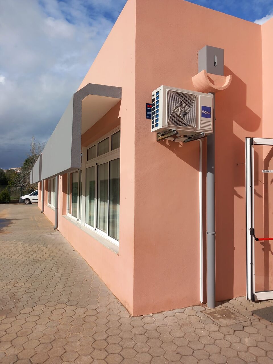 Unidade exterior de ar condicionado Haier na fachada de escola primária, Portimão