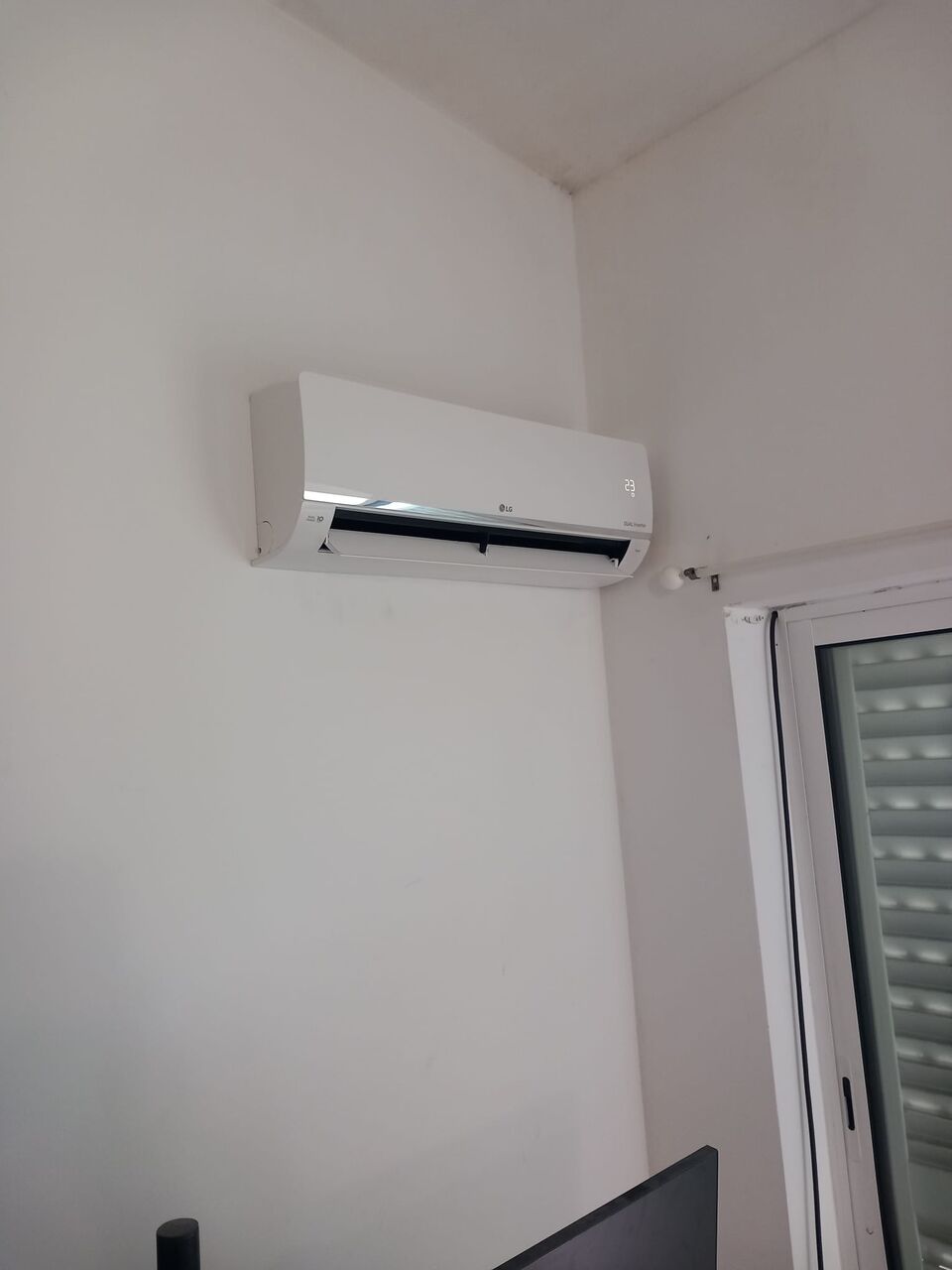 Unidade interior de ar condicionado LG instalada em quarto com secretária, Portimão
