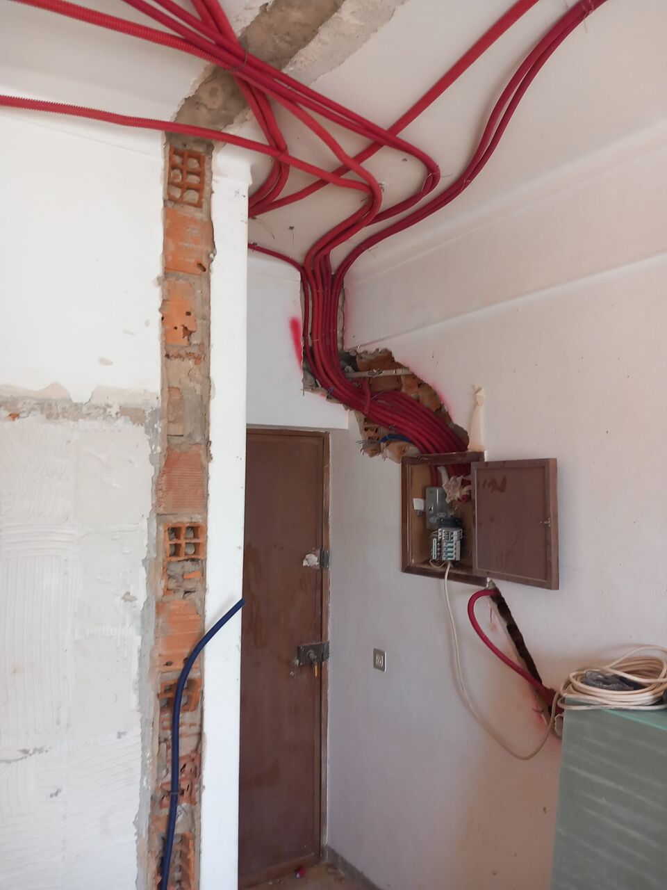 Instalação elétrica em fase de obra, com cablagem nova à vista em parede