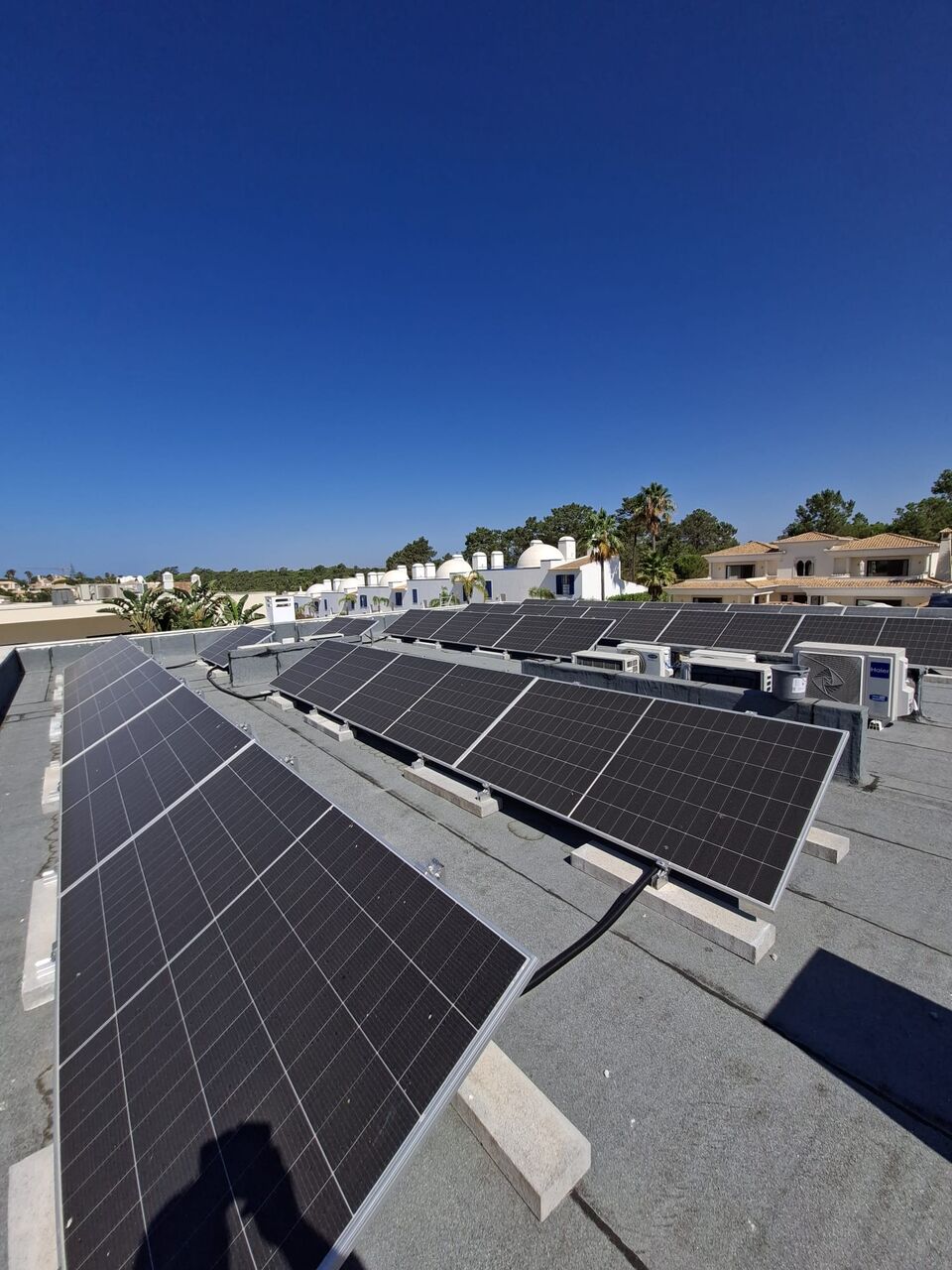 Painéis solares fotovoltaicos instalados em cobertura, vista sobre zona residencial, Albufeira