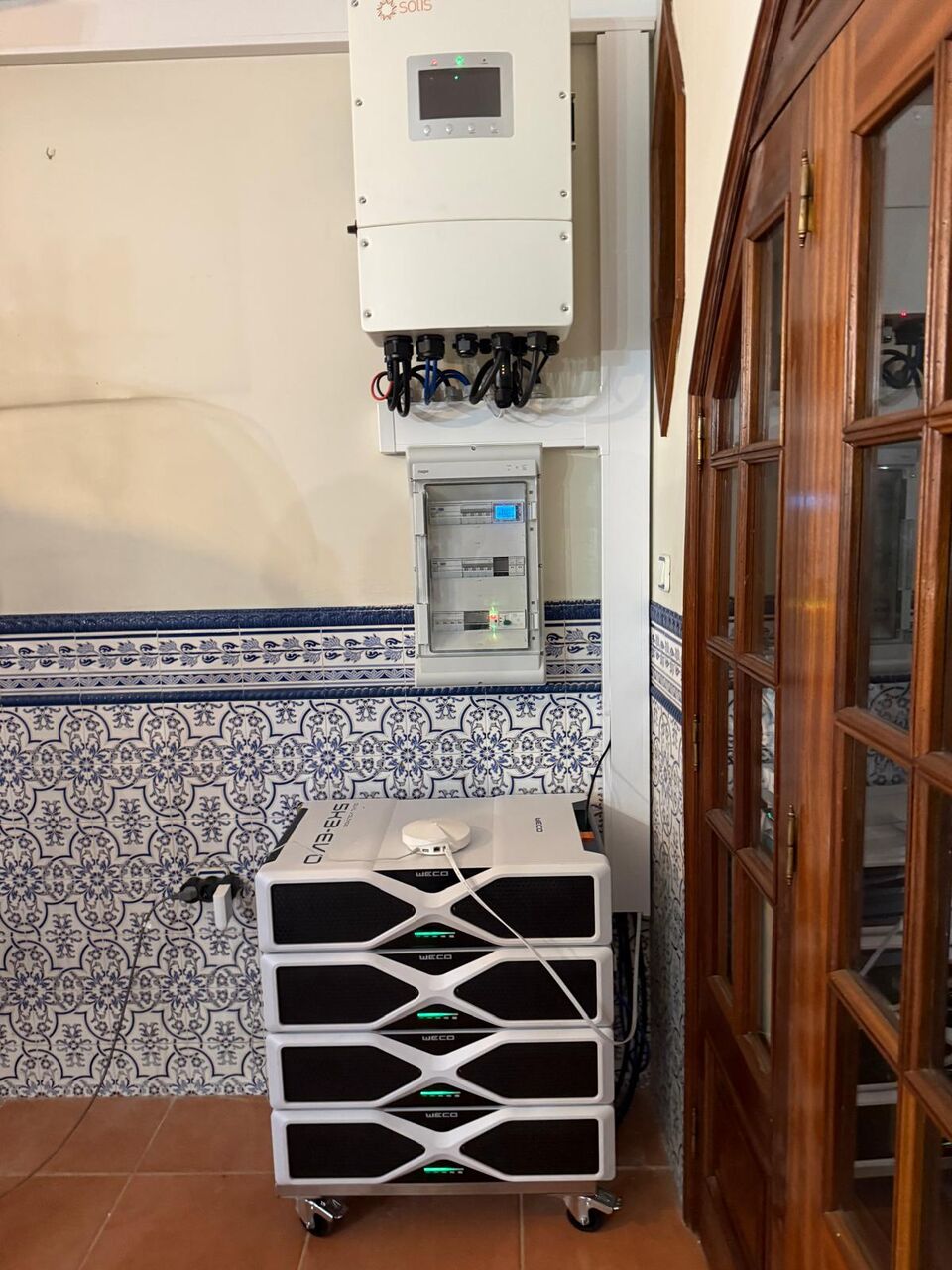 Inversor solar Huawei e quadro elétrico instalados em entrada de moradia com azulejos tradicionais, Albufeira