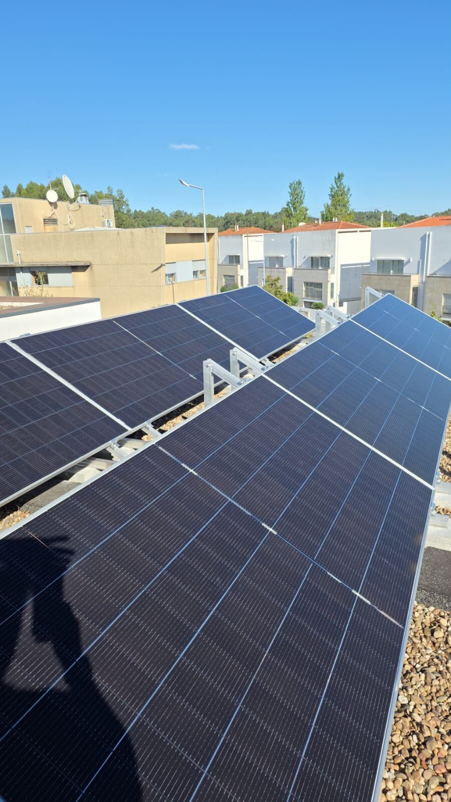 Painéis solares fotovoltaicos instalados em telhado, vista sobre zona urbana, Albufeira