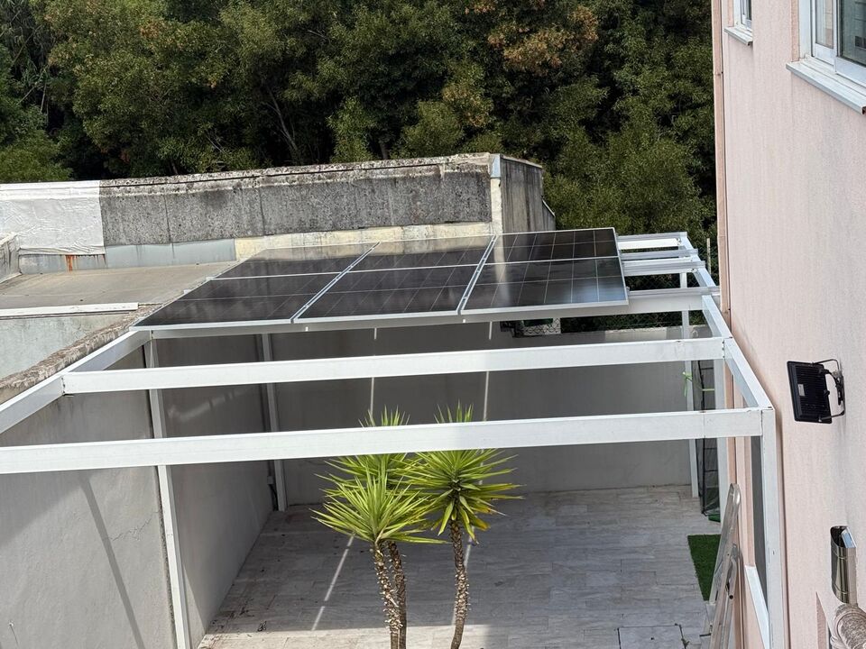 Estrutura de painéis solares fotovoltaicos instalada em pérgola, com palmeira, Albufeira