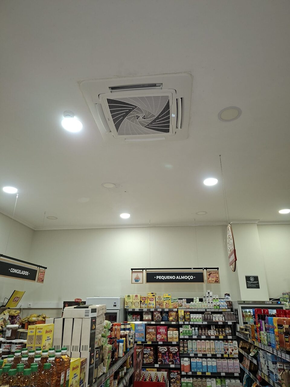 Unidade de climatização de cassete Haier instalada no teto de um supermercado Amanhecer